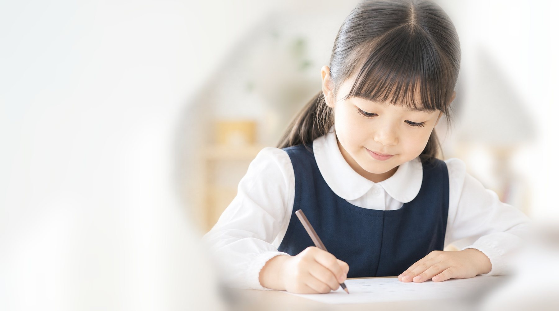 机でプリントに取り組む女の子